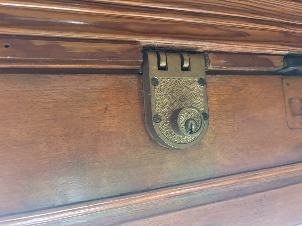 Brass rim deadbolt installed on a wooden door